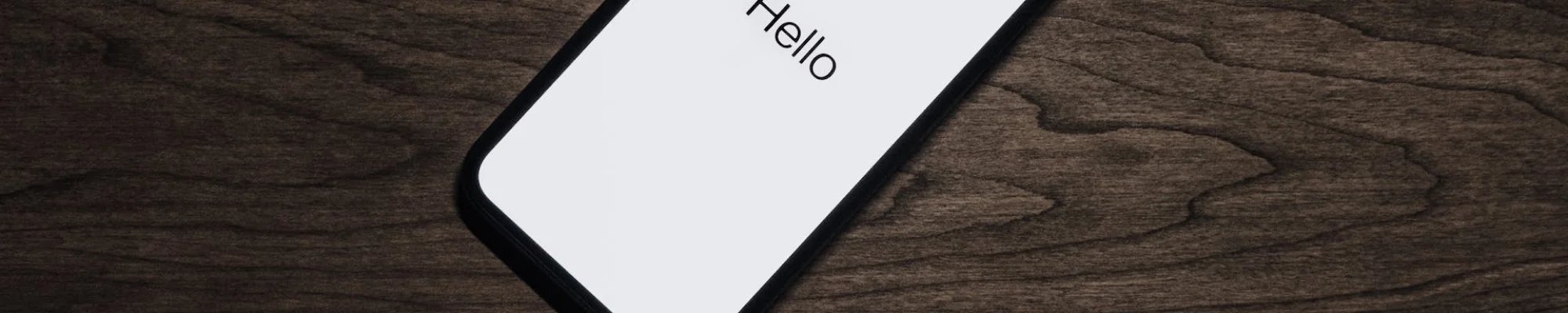 Mobile phone with a white screen that reads Hello